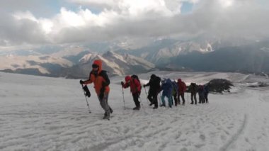 Kışın İskandinav yürüyüşü. Şarjör. Bir grup insan ormanda güzel karlı dağların arka planında spor yapıyor. Yüksek kalite 4k görüntü
