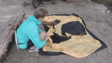 Orman yürüyüşü. Şarjör. Ormana giden ve sokakta yemek pişirmek için çadır kuran bir adam. Yüksek kalite 4k görüntü