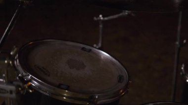 Davulcuya yakın çekim. Şarjör. Davulda sopalarla aktif çalmak. Müzisyen eski davul setinde ritmi yener.