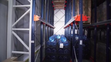 Bir deponun içinde saf şişe su rafları. Yaratıcı. Ulaştırma ve ticaret kavramı