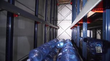 Bir deponun içinde saf şişe su rafları. Yaratıcı. Ulaştırma ve ticaret kavramı