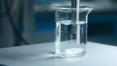 Laboratuvarda sıvı bardakta dönen madde. Stok görüntüleri. Materyal ve sıvıyla matarada kimyasal deney. Laboratuvarda profesyonel kimyasal deney.