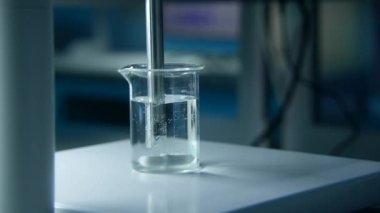 Laboratuvarda sıvı bardakta dönen madde. Stok görüntüleri. Materyal ve sıvıyla matarada kimyasal deney. Laboratuvarda profesyonel kimyasal deney.