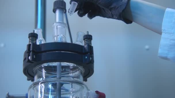 化学家带着装有旋转设备的瓶子 库存录像 戴着手套的化学家拿着瓶子去研究 旋转设备中的瓶和液的实验 — 图库视频影像