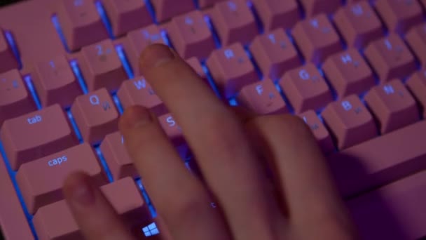 ゲーム中にキーボードで押す指のクローズアップ ストック映像 コンピュータゲームのためのピンクの光るキーボード コンピュータのキーボードの指プレスゲームキー — ストック動画