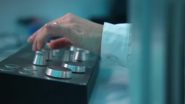 機器コントロールパネル上のボタンを回転させる女性のクローズアップ ストック映像 女性は実験装置のパネルにボタンをかける 科学研究室のボタン付き機器 — ストック動画