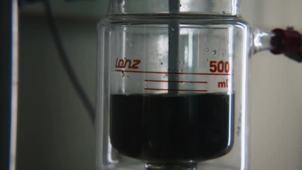 在实验室的烧瓶中旋转深色液体 库存录像 瓶装气泡液 装有化学实验装置 烧瓶中液体的化学实验及旋转或加热 — 图库视频影像