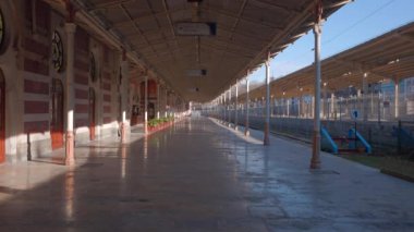 Sabahın erken saatlerinde boş tren istasyonunda. Başla. Boş platformda güneş ışığı 