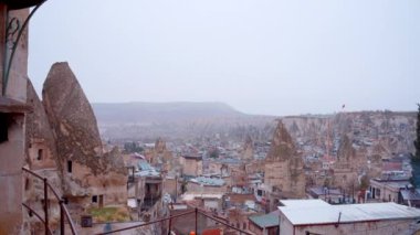 Bulutlu bir arka planda, yaz ayının güney şehrinin hava görüntüsü. Başla. Birçok binanın çatısı 