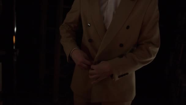 Ein Mann Brauner Jacke Befestigt Die Knöpfe Einem Dunklen Raum — Stockvideo