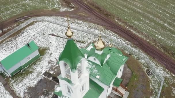 緑の屋根と金色のドームを備えた教会の空想的な眺め クリップ 春の初めに緑の農場に囲まれた教会 — ストック動画