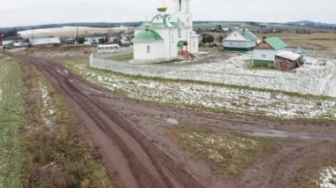 Küçük evleri ve yeni inşa edilmiş ortodoks kilisesi olan kırsal bölge manzarası. Şarjör. Köyde yaşıyor.