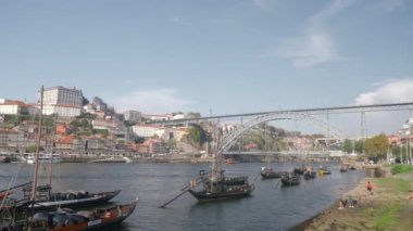 Yıkanmış teknelerle köprü ve nehir. Başla. Köprüsü olan güzel, parlak deniz kenti manzarası. Güneşli yaz gününde teknelerle körfez boyunca büyük bir köprü. 