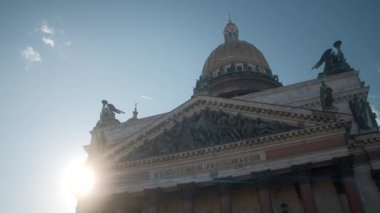 Antik katedralin altında heykeller ve kubbelerle manzarayı seyredin. Başla. Parlak güneş ve mavi gökyüzünün arka planında eski ve güzel bir katedral. Antik katedralin mimarisinde kubbe ve heykeller. 