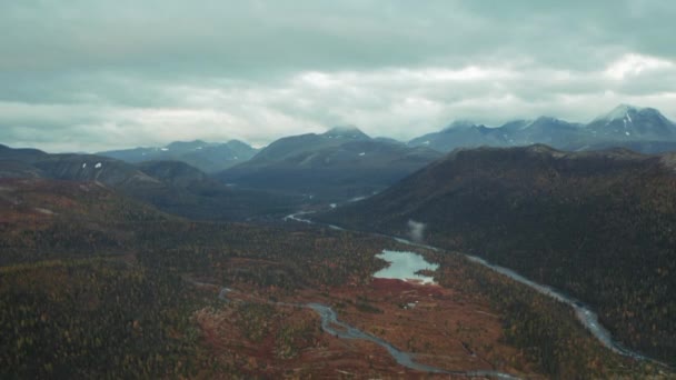 空中飞越被森林覆盖的山谷和群山环绕的令人惊奇的小湖面 深秋的日子里 从上至下的原野 — 图库视频影像