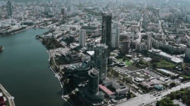 Parlak güneşin altında inşa edilmiş bir şehir. Stok görüntüleri. Büyük cam ofisler ve göl ve yürüme alanlarının yanında duran binalar. Yüksek kalite 4k görüntü