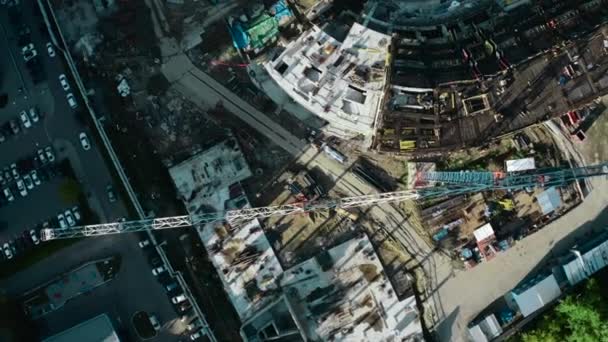城市建筑起重机和五颜六色建筑的顶视图 库存录像 有起重机和建筑物的建筑工地 阳光普照的现代城市多彩的起重机建筑 — 图库视频影像