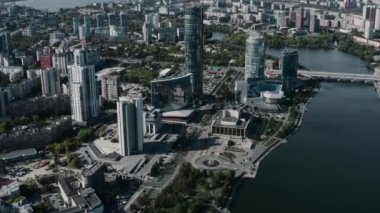 İHA 'dan alınmış mavi pencereli uzun binalar. Stok görüntüleri. Nehrin etrafında güzel evleri ve parkları olan büyük bir şehrin görkemli manzarası. Yüksek kalite 4k görüntü