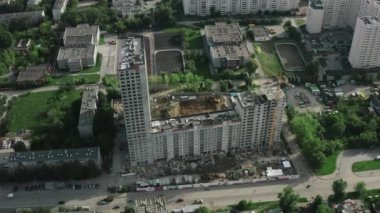 Yazın şehirde inşaat halinde olan bir yerleşim yeri. Stok görüntüleri. Yeşil bahçeli ve konut binalı şehir merkezleri. Şehirde yeşili olan konut kompleksinin inşaatı