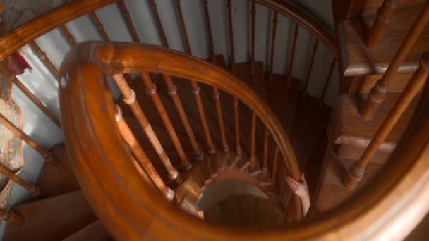 木製のツイストされた階段 アクション 黒い服を着た男が 丸みを帯びた階段を上り下りする 高品質の4K映像 — ストック動画