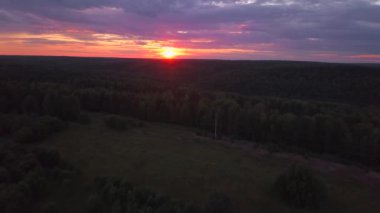 Kuşbakışı manzaralı güzel bir şehir manzarası. Şarjör. Batan güneş ve ağaçlarla çevrili yeşil alanlar ile mor gökyüzü. Yüksek kalite 4k görüntü