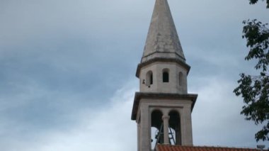 Evlerin yanında büyük bir kule. Yaratıcı. Deniz kenarındaki güzel mimari ve eski bir konseptle dağlar. Yüksek kaliteli FullHD görüntüler
