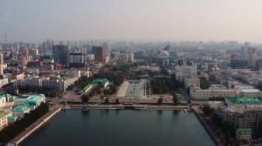 Yaz şehirleri ve binalar boyunca akan geniş bir nehir. Stok görüntüleri. Bir yaz kentinin havadan görünüşü