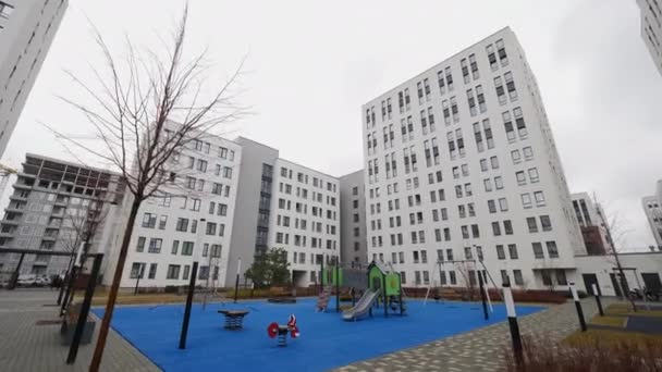 近代的な都市建築 市内の白いアパートの建物 子供の遊び場 ストック映像 住宅街の新しい高層フラットコンプレックス — ストック動画