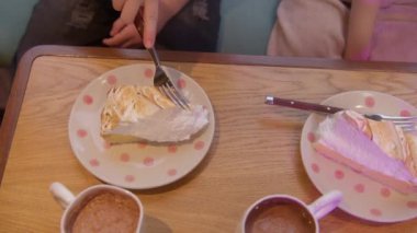 Restoranda kremalı pasta yiyen bir kızın en iyi görüntüsü. Stok görüntüleri. Tatlı pasta ve kakaonun tadını çıkarıyorum.