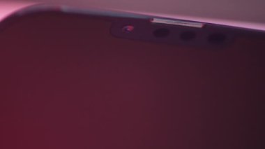 Ön kameralı bir akıllı telefon ekranına aşırı yakın çekim. Başla. Akıllı telefon ekranında ışık parladı
