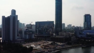 İnsansız hava aracından alınmış büyük bir şehir. Stok görüntüleri. Yüksek evleri, ofisleri, bir tapınağı ve parlak güneşli parkları olan güzel bir manzara. Yüksek kalite 4k görüntü