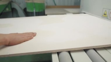 Ahşap fabrikası, işçi elleriyle tahta paneli kontrol ediyor. Yaratıcı. Endüstriyel arka plan ve bir tahta işleme makinesi