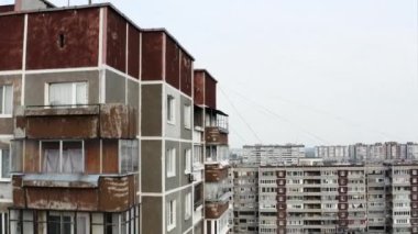 Şehrin uyku alanındaki tipik bir çok katlı bina manzarası. Stok görüntüleri. Pencereleri ve balkonları olan eski apartman dairesi.