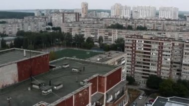 Yüksek binalar, yeşil ağaçlar ve futbol sahası olan eski uyuma alanının havadan görüntüsü. Stok görüntüleri. Yaz şehir manzarası 