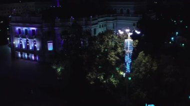 Aydınlatmalı bir gece şehri. Stok görüntüleri. Şehrin helikopter görüntüsü farklı kablolardan el fenerleriyle aydınlatılıyor. Yüksek kalite 4k görüntü