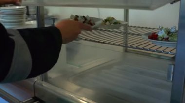 Büfede nefis bir iş yemeği. Şarjör. Özel elbiseli bir çalışan yemek odasında salata seçer. Yüksek kaliteli FullHD görüntüler