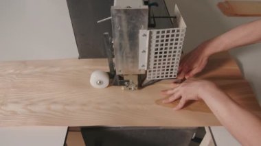 Makineyle tahta kesen işçilere yakın çekim. Yaratıcı. Atölyede ahşap tahtaları boşaltmak için ev yapımı makine. İnsan yaratıcı atölyede tahta tahtayı makine aletiyle keser. 