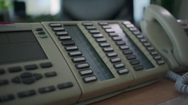 Fabrika atölyesindeki sabit hat telefonu. Şarjör. Sabit bir düğmeye basarak bir adamın elini kapat.