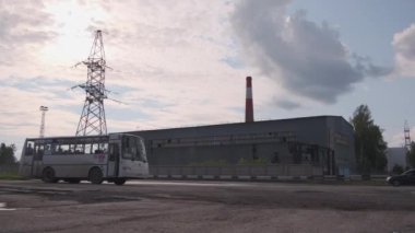 Sırbistan - Belgrad, 20 Mayıs 2023: Toplu taşımacılık ve fabrika bacası olan küçük bir kentin sanayi manzarası. Şarjör. Otobüs ve kamyon yolda ilerliyor.