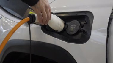 Elektrikli arabaya yakın çekim. Medya. Benzin istasyonunda modern elektrikli araba deposu. İstasyonda yeni elektrikli araba şarjı. 