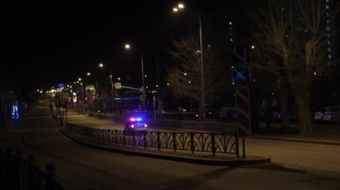 Polis arabalı sokak. Kavram. Devriye arabalı bir gece sokağı. Polis arabasının yanıp sönen ışıklarıyla. 