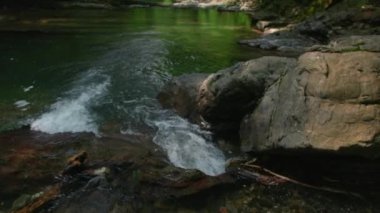 Güzel küçük şelale ve dev taşlar. Yaratıcı. Vahşi gölün soğuk dağlık nehri
