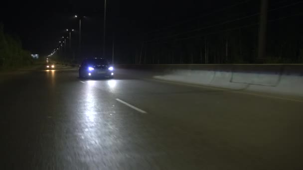 一条漆黑的夜路 一辆慢行的小车 夜间在灯光下缓缓行驶 高质量的4K镜头 — 图库视频影像