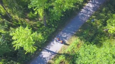 Helikopterden güneşli bir manzara. Şarjör. Çalışan üniformalı gençler bir inşaat nesnesini bitirmek için parkta yürüyorlar. Yüksek kalite 4k görüntü