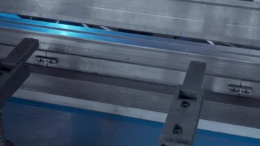 Onu yavaşça katlayan bir makineye yerleştirilmiş metal bir levha. Yaratıcı. Otomatik metal katlama ve bükme makinesi