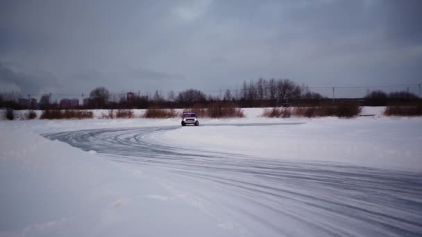カーレース クリップ 冬は雪が降り ロシアの車の模型が青空に向かって氷の上に滑っている 高品質の4K映像 — ストック動画