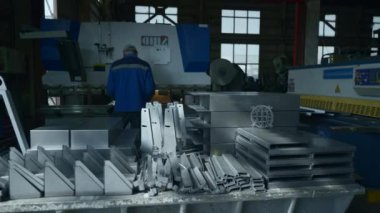 Prefabrik metal parçaları olan bir fabrika işçisi. Yaratıcı. Fabrika yapılarının montajı için metal parçalar. Detaylara göre, işçiler sanayi santralinde inşaat veya makine monte ediyorlar. 