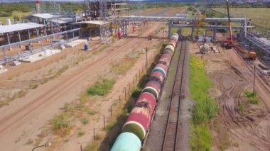 Demiryolu ve istasyon inşaatı devam ediyor. Şarjör. Yük treni inşaat halindeki platformun raylarında duruyor. Demiryolu istasyonu yaz günü demiryolu yakınlarında yapım aşamasında.. 