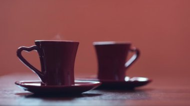 Bir fincan kahve içen adamın yakın çekimi. Kavram. Masada sıcak içecek olan iki kupa. Sıcak kahve fincanlarıyla ev yapımı bardaklar.. 