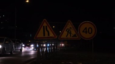 Gece şehrinde yol tamiri izleri var. Kavram. Gece kentinde trafik sıkışıklığı olan otobanda yol çalışır. Gece ayakta duran arabalarla şehir yolunda tamirat.. 